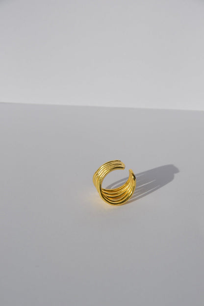 Bague ajustable plaquée or faite main par nos artisans.  Découvrez l'essence de la sophistication contemporaine avec notre bague Lignes, une pièce qui marie habilement simplicité et élégance.  Détails du Design :  Design : Minimaliste et géométrique, avec des lignes nettes et épurées qui captent la lumière.