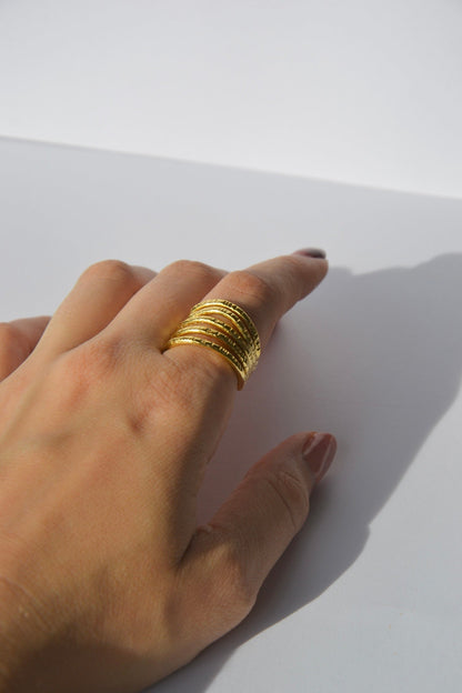 Bague ajustable plaquée or faite main par nos artisans.  Découvrez l'essence de la sophistication contemporaine avec notre bague Lignes, une pièce qui marie habilement simplicité et élégance.  Détails du Design :  Design : Minimaliste et géométrique, avec des lignes nettes et épurées qui captent la lumière.