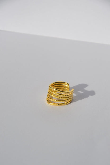 Bague ajustable plaquée or faite main par nos artisans.  Découvrez l'essence de la sophistication contemporaine avec notre bague Lignes, une pièce qui marie habilement simplicité et élégance.  Détails du Design :  Design : Minimaliste et géométrique, avec des lignes nettes et épurées qui captent la lumière.