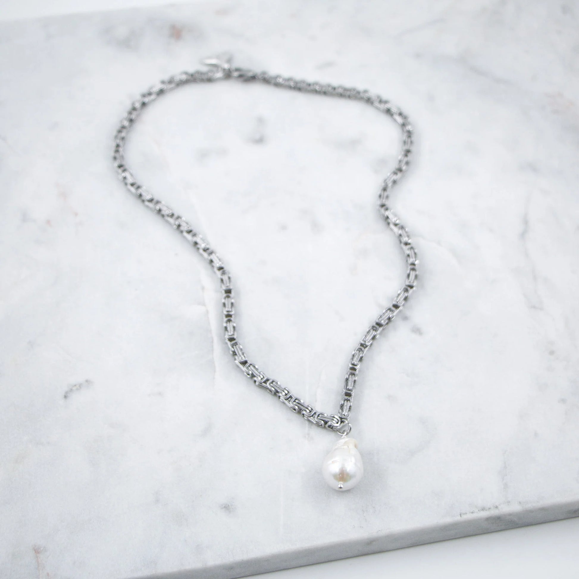 Ajoutez une touche de raffinement discret avec le Collier Perle et Chaîne Argentée, une pièce qui allie sophistication et simplicité. Orné d’une perle, ce collier se distingue par son élégance sobre, parfait pour accompagner aussi bien une tenue de jour que de soirée.